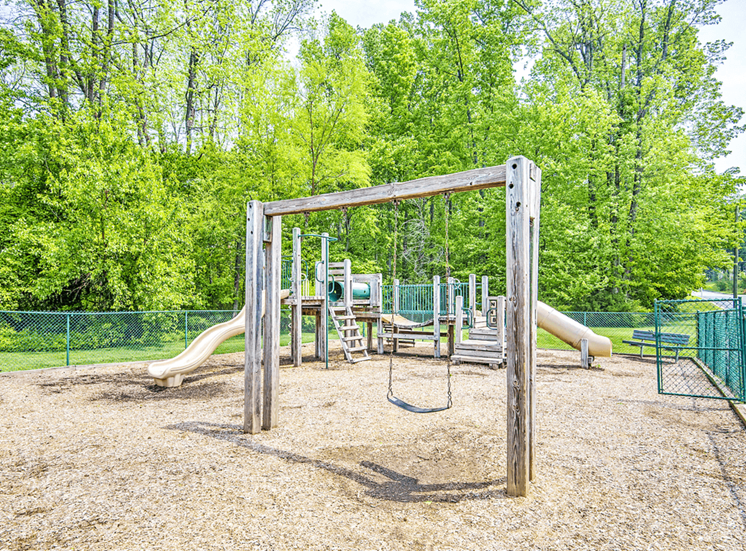 Fenced in Wooden Playground with Swing Set on Mulch